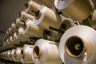 Kumaş yapımında beyaz iplikli pek çok bobin kullanılır.