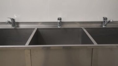 Metal bir lavaboya monte edilmiş krom kaplama su musluğu.