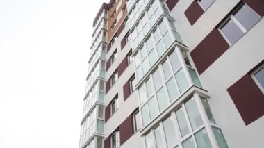Yeni konut binasının duvarında balkonlar ve apartman pencereleri var.