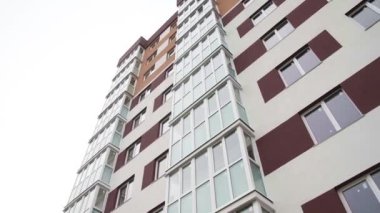 Yeni konut binasının duvarında balkonlar ve apartman pencereleri var.