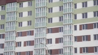 Yeni konut binasının duvarında balkonlar ve apartman pencereleri var.
