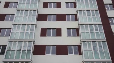 Yeni konut binasının duvarında balkonlar ve apartman pencereleri var.
