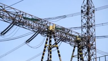 Mavi gökyüzü arka planında yüksek voltajlı güç transformatörü.