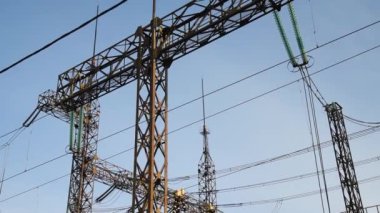 Mavi gökyüzü arka planında yüksek voltajlı güç transformatörü.