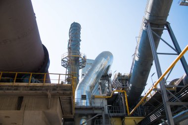 Çimento ve bina karışımı üretmek için ekin. Fabrika yapıları, mavi gökyüzüne karşı borular.