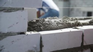 Duvarcı işçisi dış duvara tuğla döşüyordu. Tuğla döşeyen profesyonel inşaat işçisi.