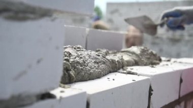 Duvarcı işçisi dış duvara tuğla döşüyordu. Tuğla döşeyen profesyonel inşaat işçisi.