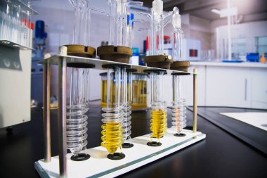 Sarı sıvı yağ içeren test tüpü kimya şişesi geri dönüşüm ve yağlama malzemeleri satışından. Motor yağı konsepti denetleniyor