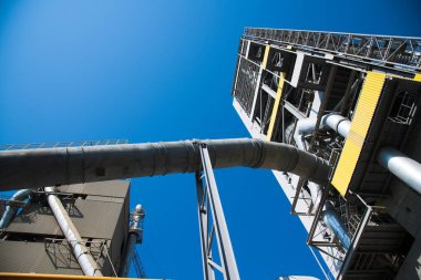 Çimento ve bina karışımı üretmek için ekin. Fabrika yapıları, mavi gökyüzüne karşı borular.