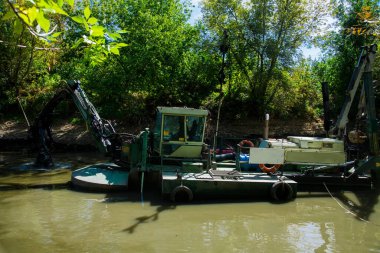 İşçiler, toprağı sudan kazmak gerektiğinde bir süzgeç kullanırlar.
