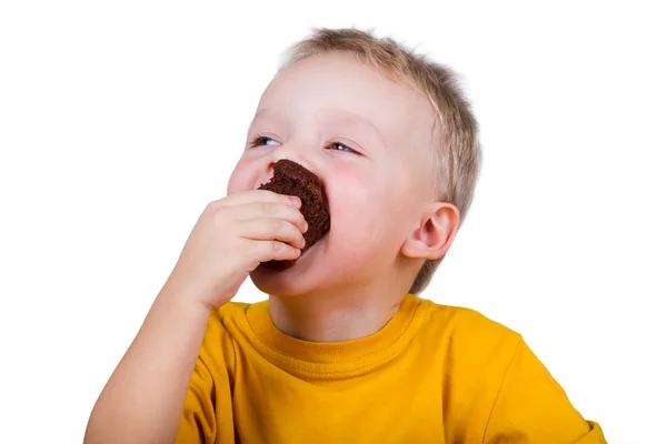 Menino pequeno comendo um queque de chocolate — Fotografia de Stock