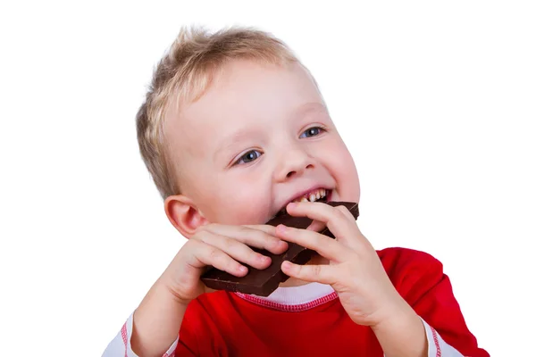 Menino pequeno comendo barra inteira de chocolate — Fotografia de Stock