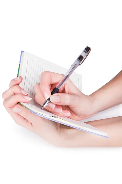 Cuaderno con bolígrafo en manos femeninas — Foto de Stock