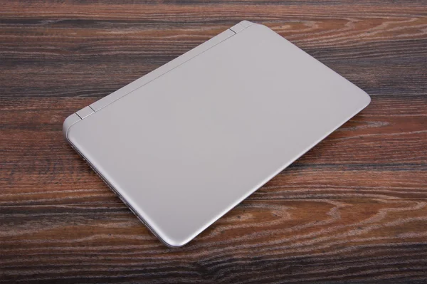 Gesloten laptop op een houten — Stockfoto