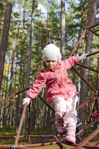 Menina escalando em um equipamento de playground — Fotografia de Stock