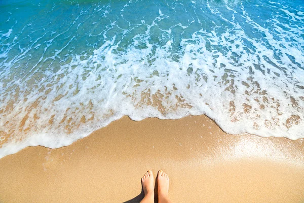 Mousse de mer, vagues et pieds nus sur une plage de sable — Photo