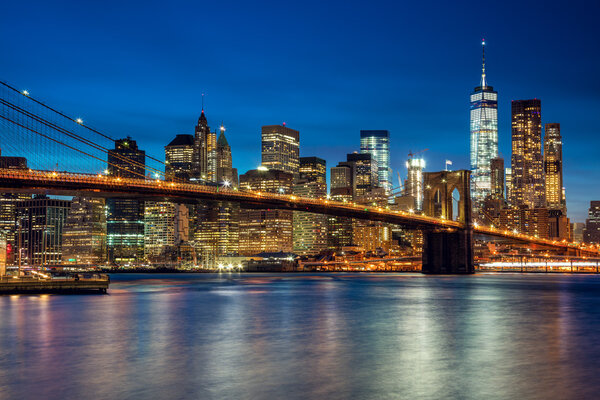 Manhattan with skyscrapers and Brooklin Bridge by evening, New York City illumination