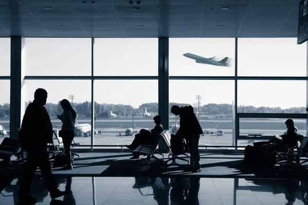 Personas reales esperando el vuelo dentro de la terminal del aeropuerto — Foto de Stock