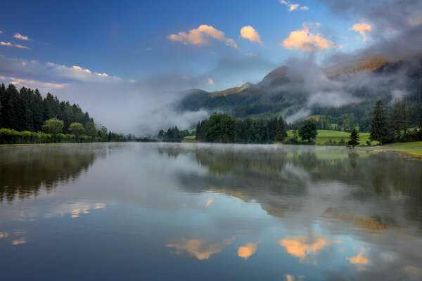 Foggy Morning on lake landscape, with beautiful clouds and refle