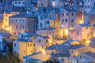 Eski evlerin arka planı. Akşam aydınlatmasında küçük bir kasaba, duvar kâğıdı. Sorano, Toskana, İtalya, Avrupa.