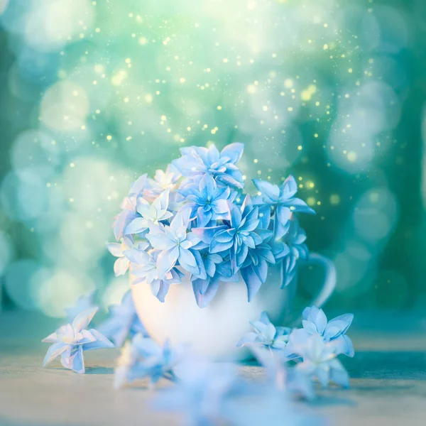 Delicate floral artistic background with blue flowers and bokeh. Conceptual romantic wallpaper design. Fragile blue flowers super macro