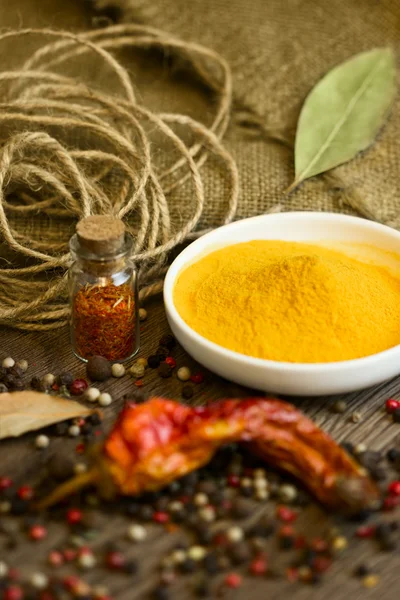 Turmeric in saucer with spices — Stock Photo, Image