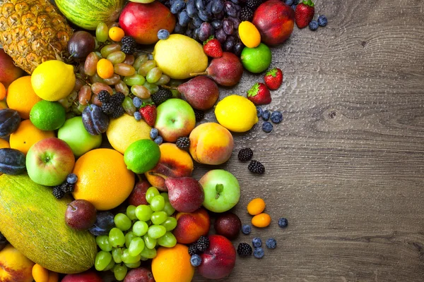 Campuran Buah-buahan segar dengan tetesan air di meja kayu yang gelap — Stok Gambar Campuran Buah-buahan segar dengan tetesan air di meja kayu yang gelap Stok Foto Bebas Royalti