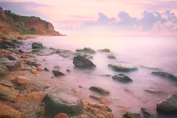 Colorido atardecer sobre el mar y la costa rocosa — Foto de Stock