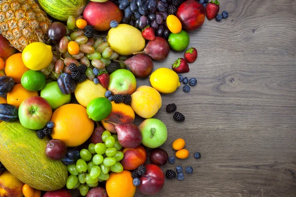Mischung aus frischen Früchten auf dunklem Holztisch — Stockfoto