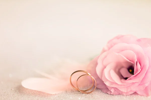 Свадебный фон с золотыми кольцами, нежный цветок и светлая булавка — стоковое фото