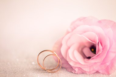 Yumuşak pembe düğün arka plan ile yüzük ve çiçek