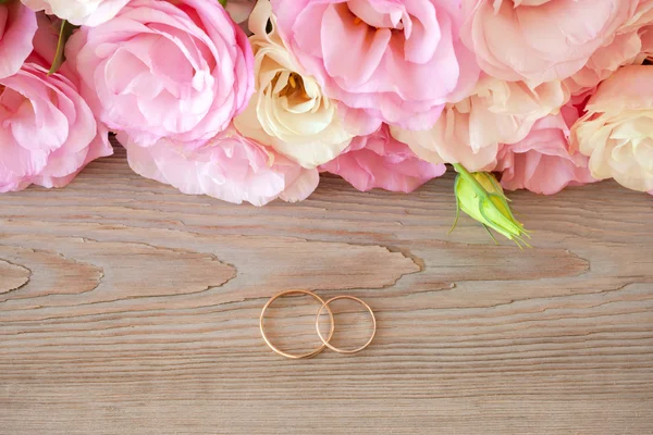 Vintage bruiloft achtergrond met gouden ringen en mooie bloem — Stockfoto