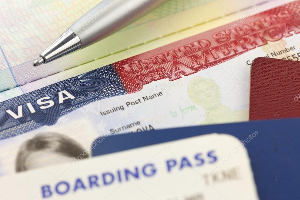 USA Visa, passports, boarding pass and pen - foreign travel 