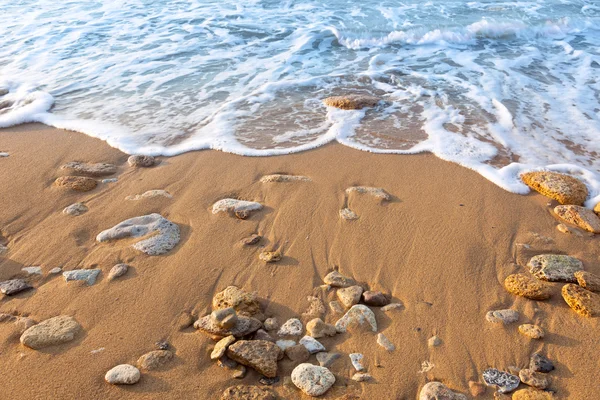 Ola del océano en la playa con arena y piedras — Foto de Stock