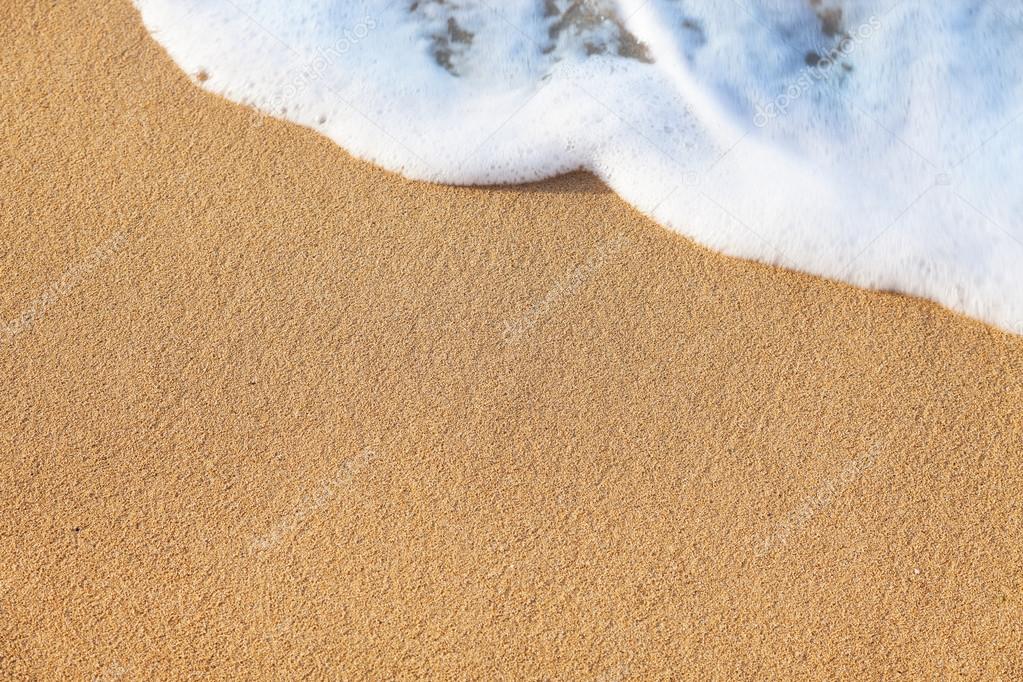 Summer background - wave of the sea on the sandy beach