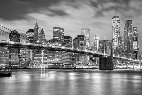 Manhattan skyscrapers and Brooklyn Bridge - city illuminations, black and white colors, New York, USA