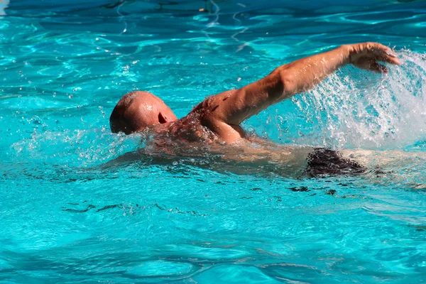 Mannen simmar i poolen — Stockfoto