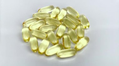 Beyaz arka planda izole edilmiş sarı vitamin hapları.