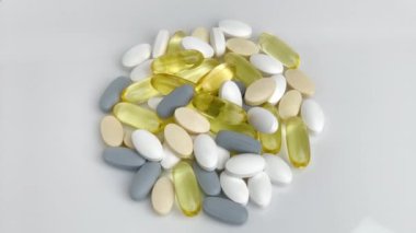 Beyaz arka planda izole edilmiş vitamin hapları yığını