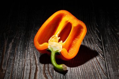 sliced orange bell pepper on wood background