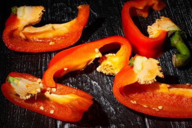 Tahta arka planda dilimlenmiş dolmalık biber.