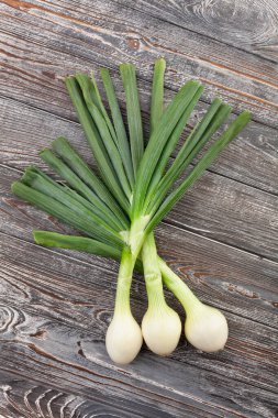 Ahşap zemin üzerine yeşil soğan