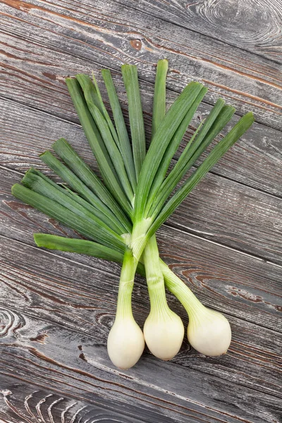 Ahşap zemin üzerine yeşil soğan