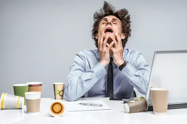 OMG! Frustrated man sitting desperate over paper work at desk.