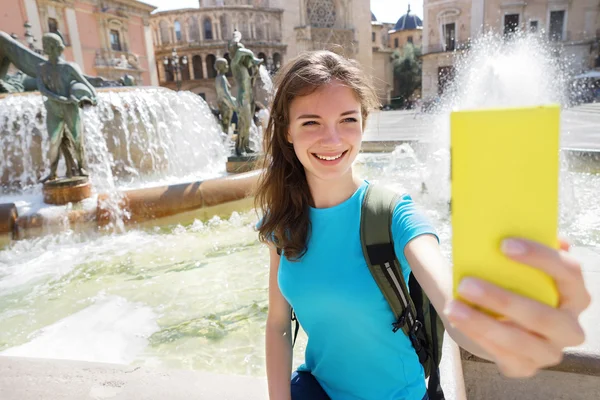 Girl tourist using smart phone camera in Valencia, Spain