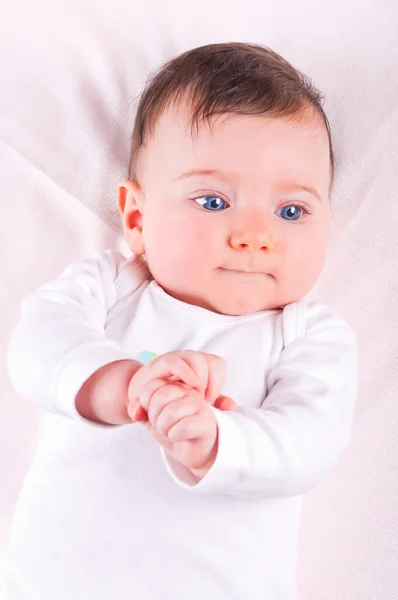 Funny Baby flicka på rosa filt. — Stockfoto