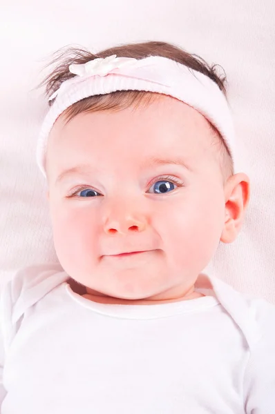 Lustiges Baby-Mädchen auf rosa Decke. — Stockfoto