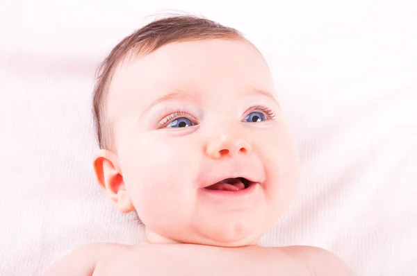 Grappige mooie babymeisje op roze deken. — Stockfoto