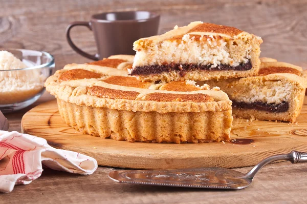 Chocolate coconut tart on wooden breadboard. — Stock Photo, Image