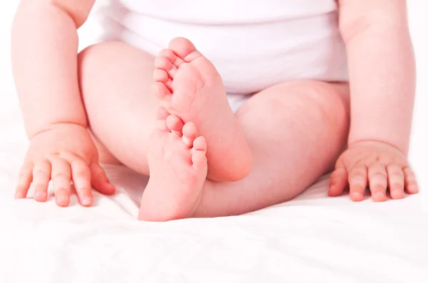 Neugeborene Babyfüße auf weißem Sofa. — Stockfoto